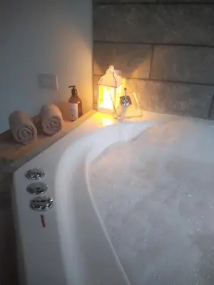 a bathroom with a bath tub with a light on it at Complejo Quiya - Departamento Los Espinillos con hidromasaje in Alta Gracia