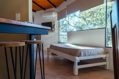a bedroom with a bed and a large window at Complejo Quiya - Departamento Los Espinillos con hidromasaje in Alta Gracia