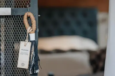 a tag on a fence with a bed in the background at OMM Suites Resort, Villa General Belgrano in Villa General Belgrano