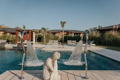 a woman sitting in front of a swimming pool at OMM Suites Resort, Villa General Belgrano in Villa General Belgrano