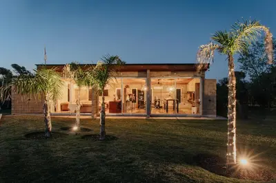 a house with two palm trees in the yard at OMM Suites Resort, Villa General Belgrano in Villa General Belgrano