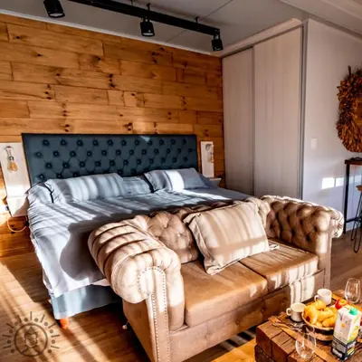a bedroom with a large bed and a couch at OMM Suites Resort, Villa General Belgrano in Villa General Belgrano