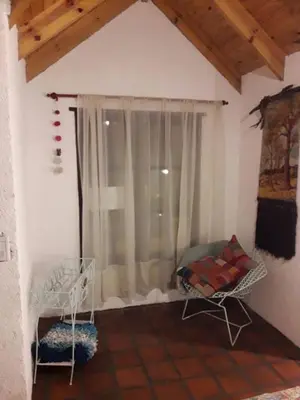 a room with a window and a chair in a room at Lola Maria Apart in Villa General Belgrano