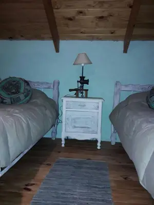 a bedroom with two beds and a table with a lamp at Lola Maria Apart in Villa General Belgrano