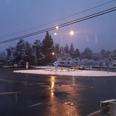 a city street with snow on the ground and street lights at Lola Maria Apart in Villa General Belgrano