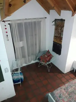 a living room with a chair and a window at Lola Maria Apart in Villa General Belgrano