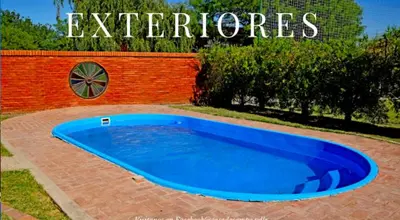 a large blue swimming pool in front of a brick wall at El Rancho Casa de Campo Exclusiva en Villa de Las Rosas Los impuestos que figuran en la publicación no se cobran in Villa de Las Rosas
