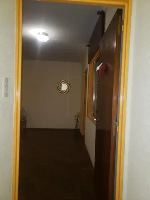 a hallway leading to a room with a door and a light at Ser Uno in Cordoba