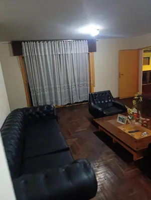 a living room with black leather couches and a coffee table at Ser Uno in Cordoba