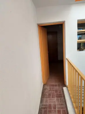 a hallway with an orange door and a staircase at Ser Uno in Cordoba
