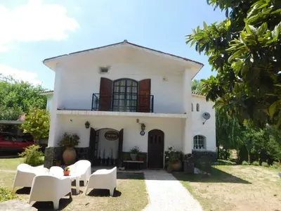 a white house with white furniture in front of it at Filipao Aparts in Santa Rosa de Calamuchita