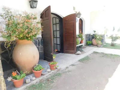 a large vase sitting next to a building with potted plants at Filipao Aparts in Santa Rosa de Calamuchita