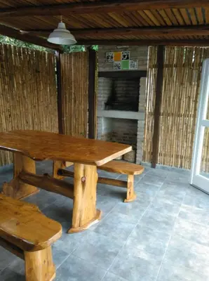 a wooden picnic table and benches in a room at Cabañas Farah Estancia Vieja ideal para 2 a 3 huéspedes in Villa Carlos Paz