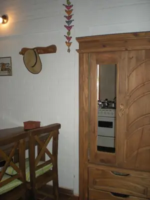 a kitchen with a wooden cabinet and a stove at Cabañas Farah Estancia Vieja ideal para 2 a 3 huéspedes in Villa Carlos Paz