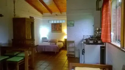 a small room with a bed and a kitchen at Cabañas Farah Estancia Vieja ideal para 2 a 3 huéspedes in Villa Carlos Paz