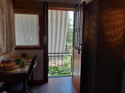 a kitchen with a table and a view of a balcony at Cabañas Farah Estancia Vieja ideal para 2 a 3 huéspedes in Villa Carlos Paz