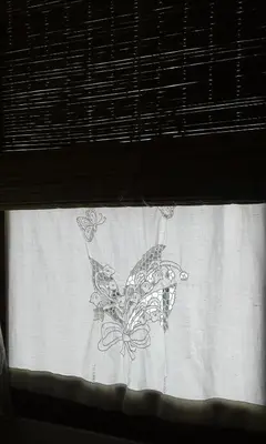 a window curtain with a drawing of a butterfly on it at Cabañas Farah Estancia Vieja ideal para 2 a 3 huéspedes in Villa Carlos Paz