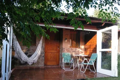 a porch of a house with chairs and a table at Cabañas Farah Estancia Vieja ideal para 2 a 3 huéspedes in Villa Carlos Paz