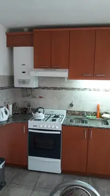 a kitchen with a white stove and brown cabinets at Maganal in Villa Carlos Paz