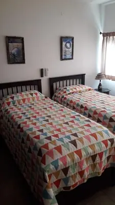 a bed with a colorful quilt on it in a bedroom at Maganal in Villa Carlos Paz