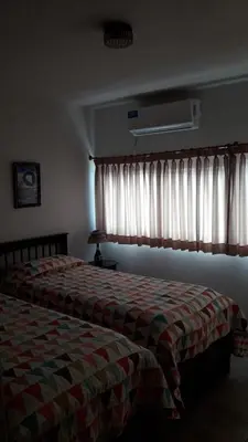 a bedroom with a bed and a window with curtains at Maganal in Villa Carlos Paz