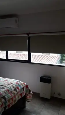 a bedroom with two windows and a bed in it at Maganal in Villa Carlos Paz