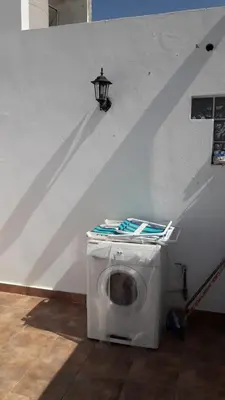 a washing machine sitting under a stairs with a light at Maganal in Villa Carlos Paz