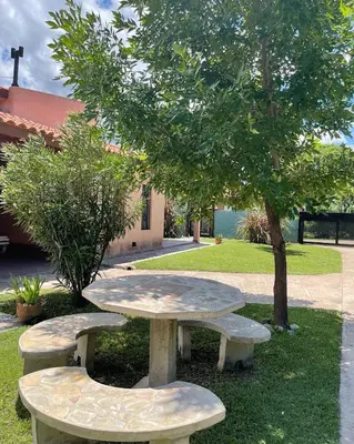 a picnic table and two benches next to a tree at Cabañas Samarana in Carpintería