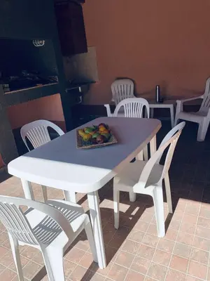 a white table and chairs with a plate of fruit on it at Cabañas Samarana in Carpintería