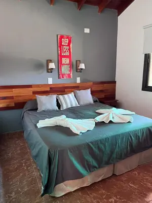 a large bed with two white towels on it at Cabañas Samarana in Carpintería