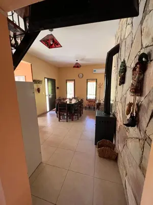 a dining room and living room with a stone wall at Cabañas Samarana in Carpintería