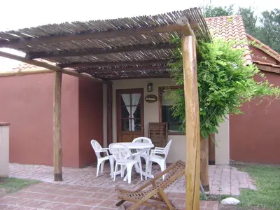 a patio with a table and chairs and a building at Cabañas La Curucucha in Nono