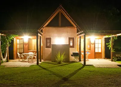a house at night with a table and chairs at Cabañas La Curucucha in Nono