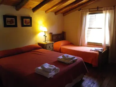 a hotel room with two beds and a window at Cabañas La Curucucha in Nono