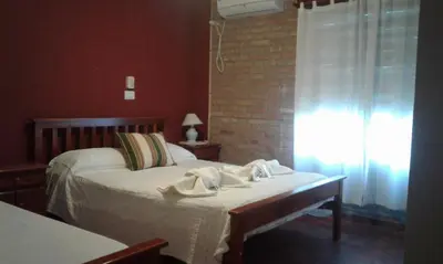 a bedroom with a bed with towels on it at Principado Sierras Hotel in Mina Clavero
