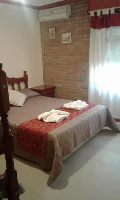 a bedroom with a bed with two towels on it at Principado Sierras Hotel in Mina Clavero