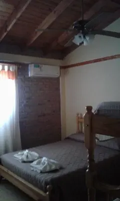 a bedroom with a bed with a ceiling fan at Principado Sierras Hotel in Mina Clavero