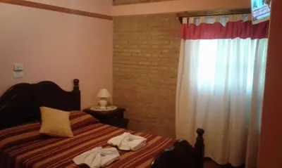 a bedroom with a bed with towels on it at Principado Sierras Hotel in Mina Clavero