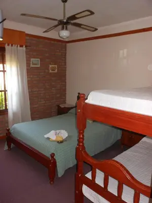 a bedroom with two bunk beds and a ceiling fan at Principado Sierras Hotel in Mina Clavero