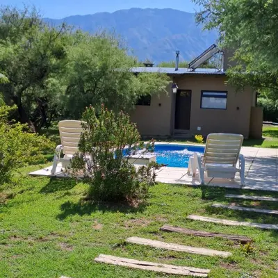 two chairs and a swimming pool in a yard at Cabañas Altos de San Blas in San Javier
