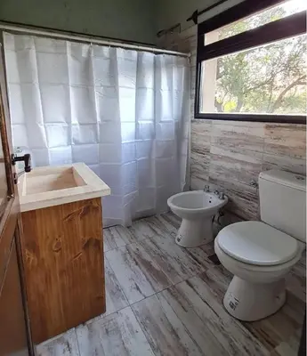 a bathroom with a toilet and a sink and a window at Cabañas Altos de San Blas in San Javier