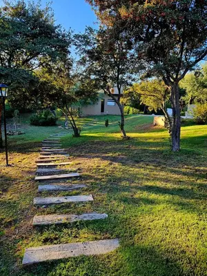 a stepping stone path in a park with trees at Cabañas Altos de San Blas in San Javier