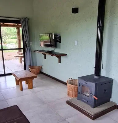 a living room with a wood stove in a room at Cabañas Altos de San Blas in San Javier