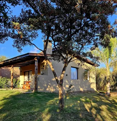 a small house with a tree in front of it at Cabañas Altos de San Blas in San Javier
