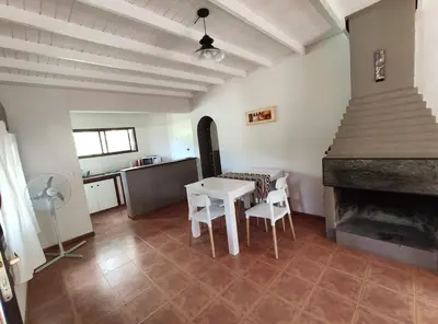 a living room with a table and a fireplace at Casa Etor in Merlo