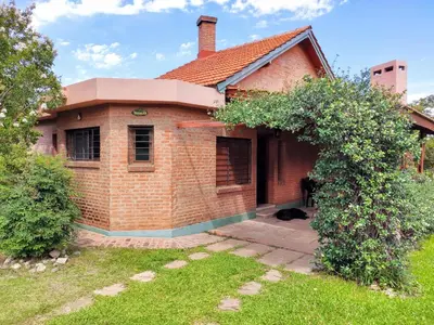 a brick house with a dog sitting outside of it at Casa Etor in Merlo