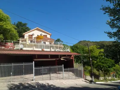 a house with a balcony on top of it at del Buen Ayre in Villa Carlos Paz