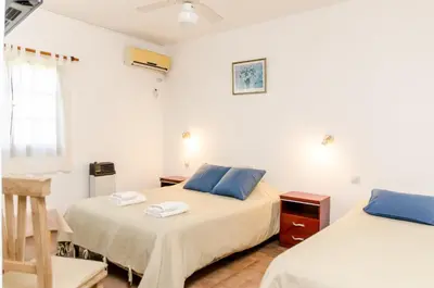 a bedroom with two beds with blue pillows at del Buen Ayre in Villa Carlos Paz