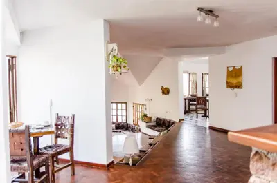 a living room with white walls and a table and chairs at del Buen Ayre in Villa Carlos Paz