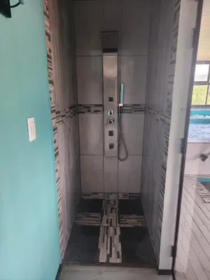 a shower in a bathroom with ailed floor at Complejo Los Cipreses in Villa Carlos Paz